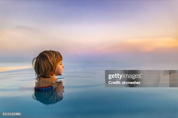 profielmening van leuk weinig jongen in de oneindigheidspool. - infinity pool stockfoto's en -beelden