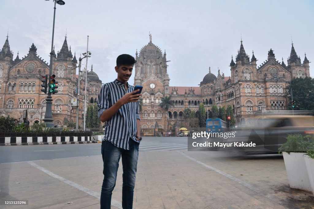 Teenage boy standing in front of CST Railway station