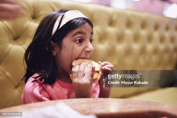 girl (6-7 years) eating burger - kid eating burger bildbanksfoton och bilder