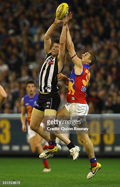Leigh Brown of the Magpies marks infront of Matt Maguire of the Lions during the round 22 AFL match between the Collingwood Magpies and the Brisbane...