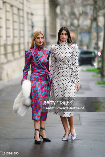 Teresa Andres Gonzalvo wears long bejeweled earrings, a colored turtleneck lustrous long silky dress with printed argyle geometric patterns, a white...