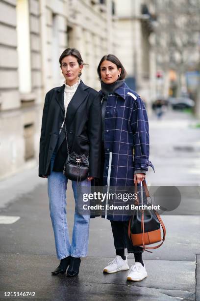 Sylvia Haghjoo wears a white turtleneck ruffled top, a black oversized blazer jacket, a Chanel bag, blue denim jeans pants, pointy shoes ; Julia...