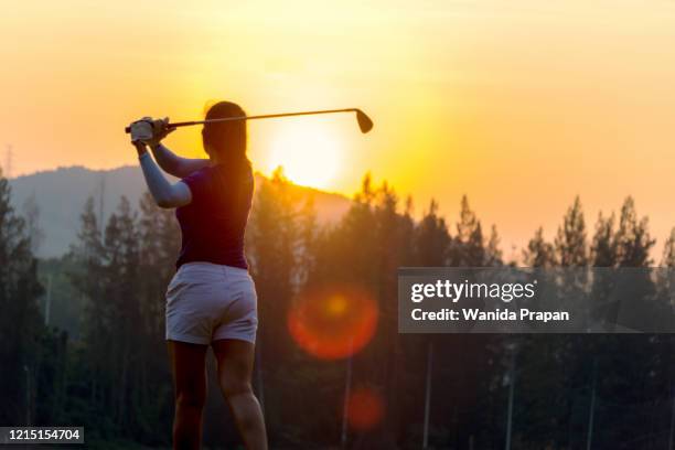 golfer sport course golf ball fairway.  people lifestyle woman playing game golf tee of on the green grass sunset background.  asia female player game shot in summer.  healthy and sport outdoor - natural shot female stock-fotos und bilder