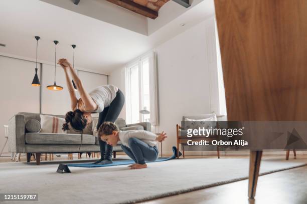 mother with children doing yoga at home - weightlifting room stock pictures, royalty-free photos & images