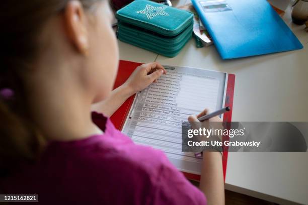 In this photo illustration a girl is doing her homework, learning how to write on May 19, 2020 in Bonn, Germany.