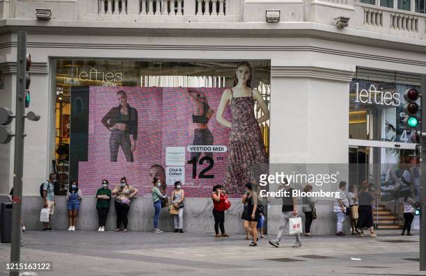 Customers queue according to social distancing rules outside a Lefties fashion retailer, operated by Inditex SA, in Madrid, Spain, on Monday, May 25,...