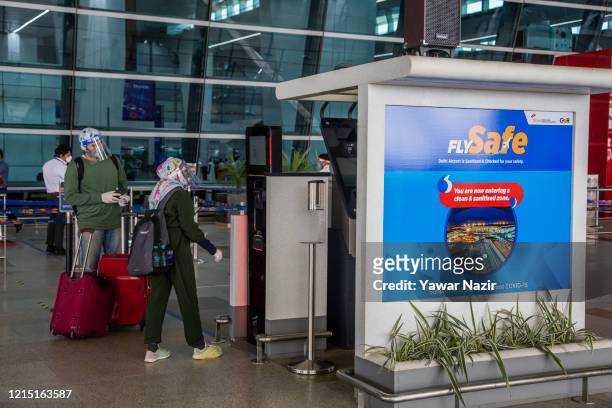 Indian travelers waits at the drop-off point before entering Terminal 3 of the Indira Gandhi International Airport, as the country relaxed its...