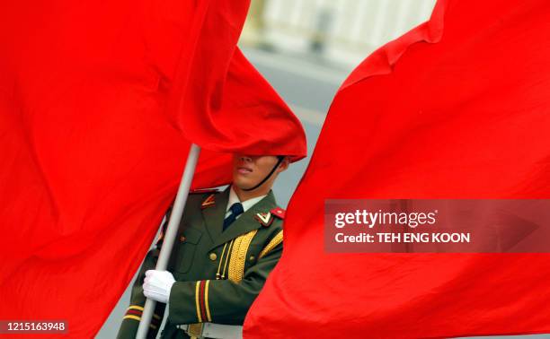 An Chinese honor guard is covered by a flag during a welcoming ceremony for visiting Spanish King Juan Carlos I, at the Great Hall of the People in...