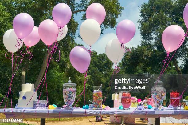 balloons and candy laid out on a table outside for a baby shower - babyshower stockfoto's en -beelden