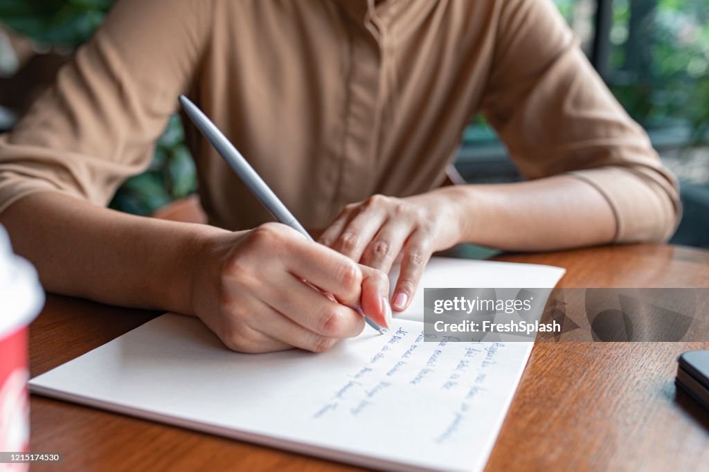 Planning Ahead: Cropped Shot of an Anonymous Woman's Hands Writing Notes in a Notebook