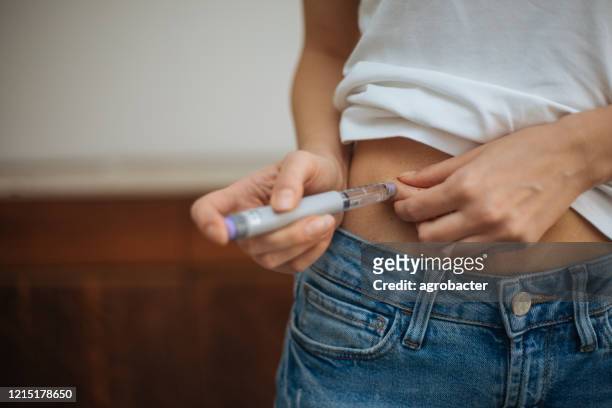 vrouw die insulineinjectie doet - spuit stockfoto's en -beelden