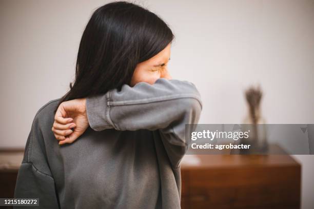 portrait of a young woman sneezing - allergies indoors stock pictures, royalty-free photos & images