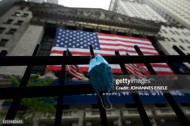 Face mask is seen in front of the New York Stock Exchange on May 26, 2020 at Wall Street in New York City. - Global stock markets climbed Monday,...