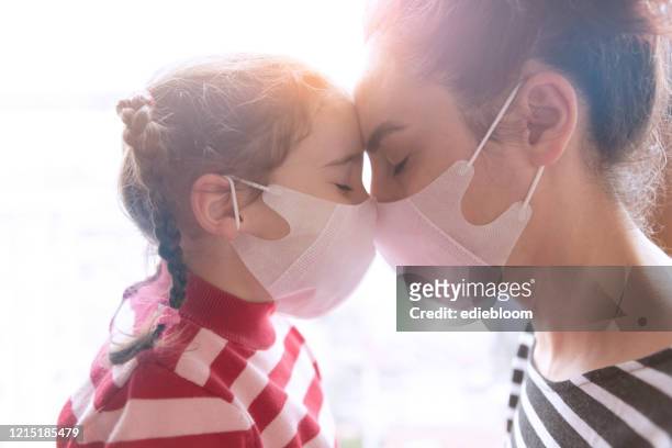 mother and little daughter wearing surgial mask - pandemic illness stock pictures, royalty-free photos & images