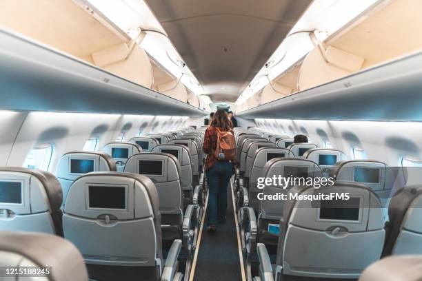 frau, die im flugzeug den gang geht - boarding plane stock-fotos und bilder