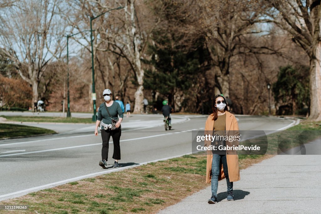 Personas con máscaras caminando en Central Park