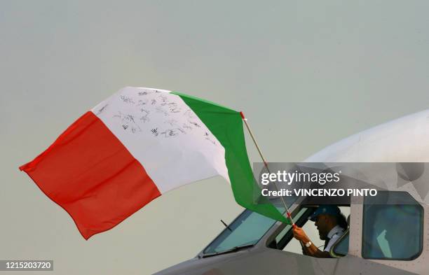 The pilot of the plane carrying the Italian football team back home, waves the national flag at Pratica di Mare airport, 35km south of Rome, 10 July...