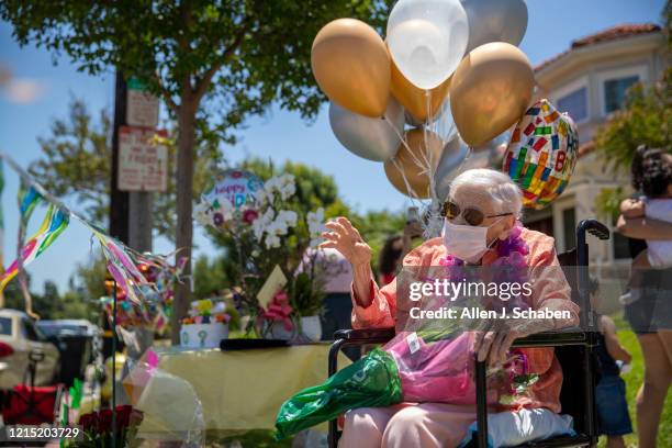 Mildred ``Millie'' Stratton waves to a caravan of cars led by the Alhambra Police and Fire parading past her home, celebrating her 102nd birthday on...