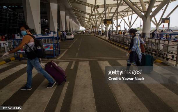 People arrive with their luggage at Terminal 3 at the Indira Gandhi International Airport, as the country relaxed its lockdown restriction on May 26,...