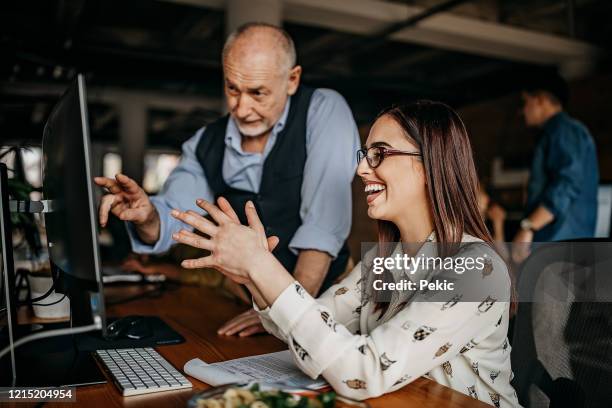 discussing business tasks with colleagues - baby boomer working stock pictures, royalty-free photos & images