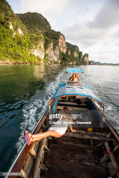 a woman enjoying a ride in a long-tail boat in thailand. - long tail boat stock-fotos und bilder