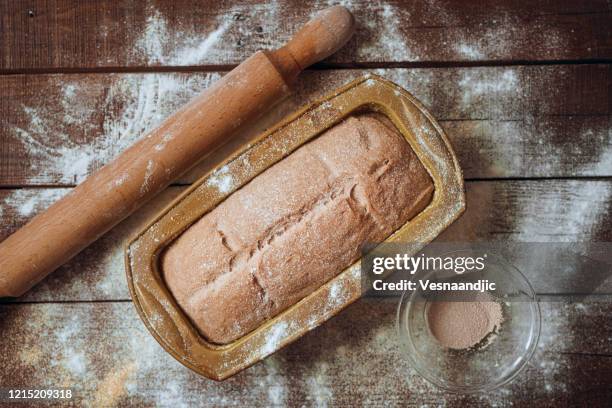 yeast integral dough raw in a mould, on a wooden table - homemade loaf of bread stock pictures, royalty-free photos & images