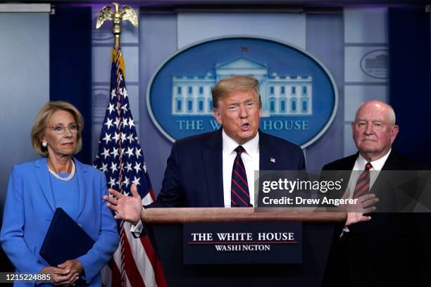 President Donald Trump sas Secretary of Education Betsy DeVos and Secretary of Agriculture Sonny Perdue look on during a briefing on the coronavirus...