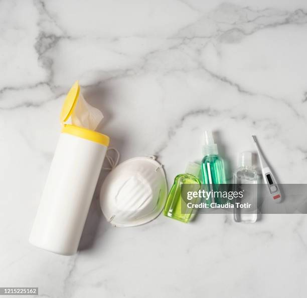 protective mask, bottles of hand sanitizers, disinfecting wipes, and a thermometer on white background - antiseptic wipe stockfoto's en -beelden