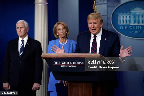 President Donald Trump speaks as Vice President Secretary of Education Betsy DeVos and Secretary of Agriculture Sonny Perdue look on during a...