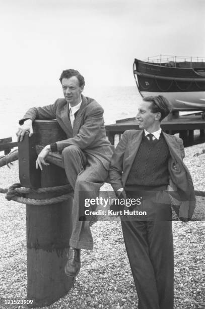 English composer and conductor Benjamin Britten on the beach at Aldeburgh, Suffolk with librettist Eric Crozier , 1949. Original Publication :...