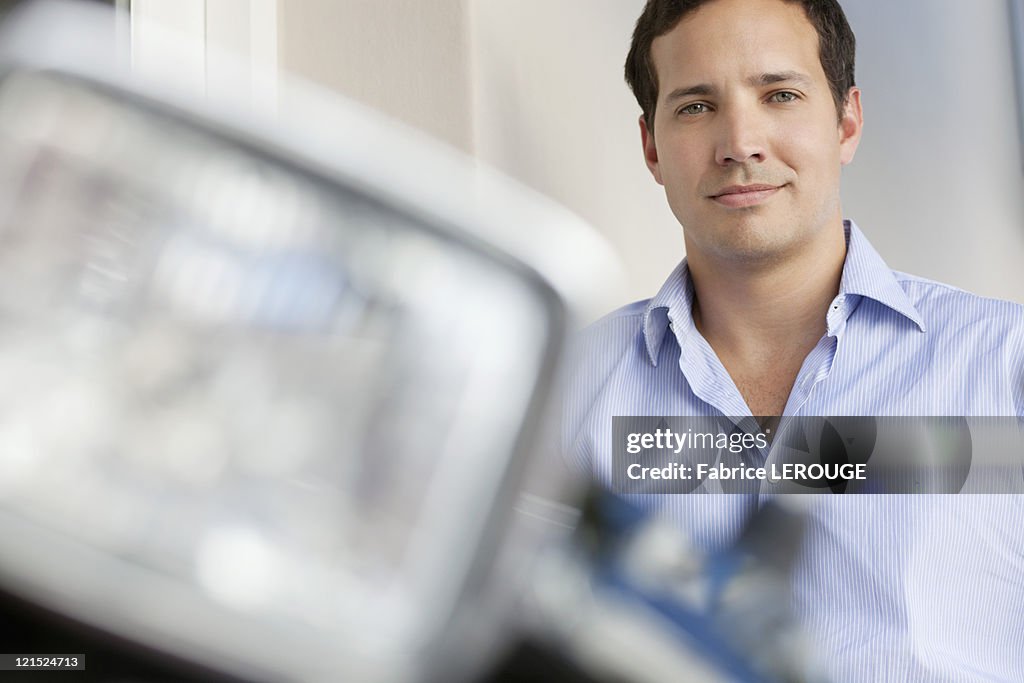 Portrait of a mid adult man standing with motorcycle in the foreground