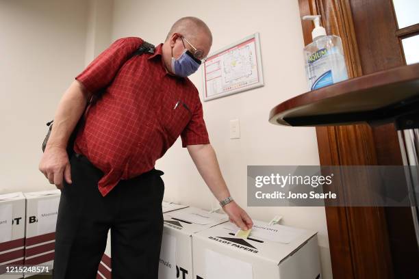 Voter is seen wearing a mask at Brisbane City hall polling booth on March 28, 2020 in Brisbane, Australia. Queensland local government elections and...