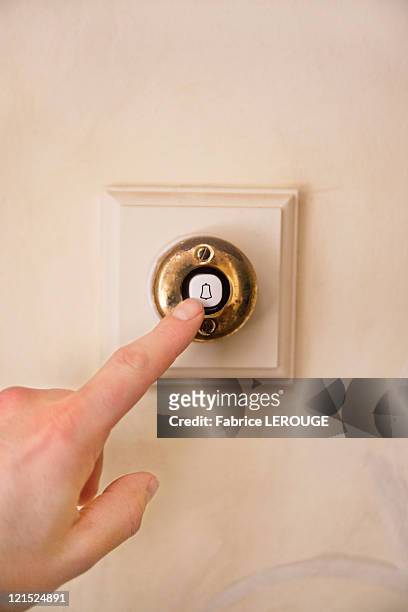 close-up of a person's hand ringing door bell - doorbell stock pictures, royalty-free photos & images