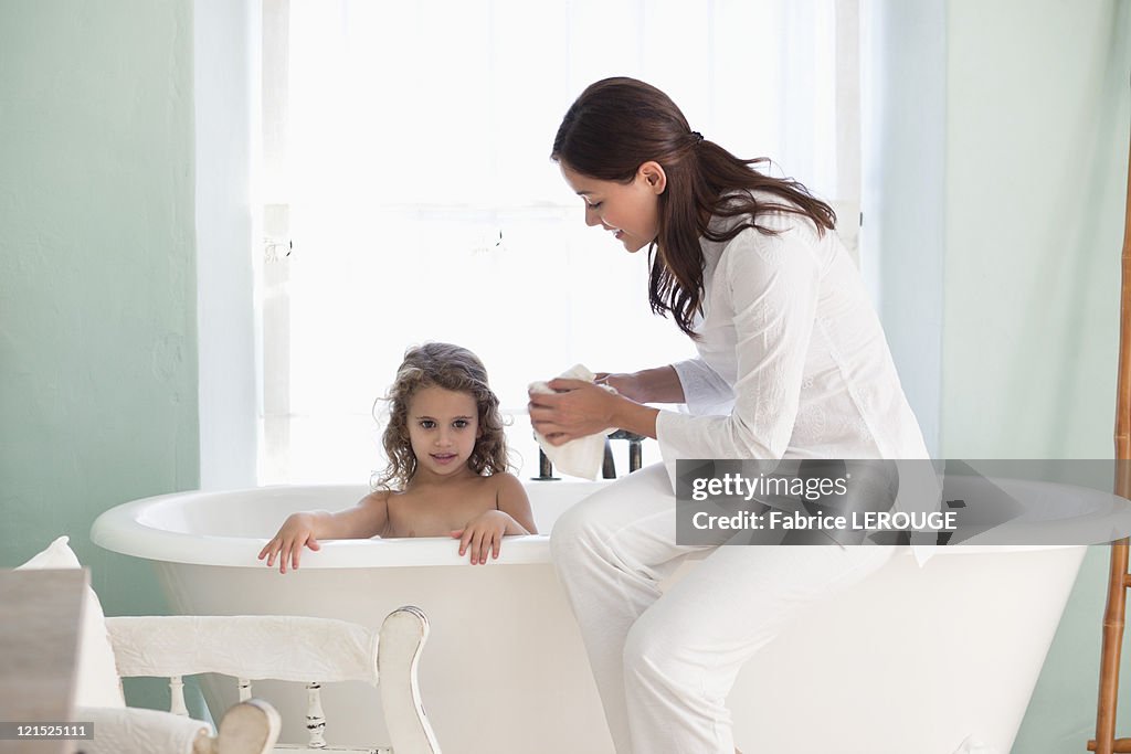 Woman giving a bath to her daughter