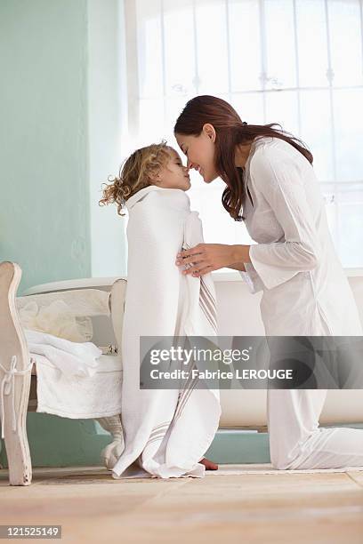 woman rubbing noses with her daughter wrapped in towel after the bath - mother daughter towel fotografías e imágenes de stock
