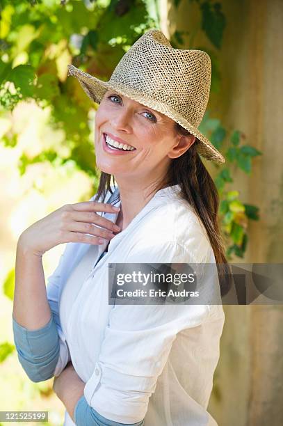 portrait of a beautiful mature woman wearing hat and smiling - strohhut stock-fotos und bilder