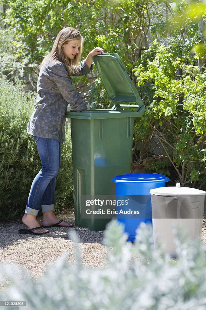 Woman looking into recycling bin