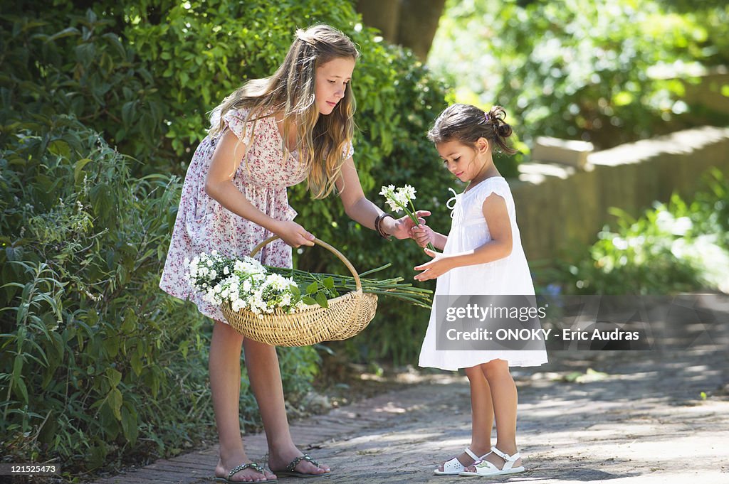 Girl giving flower to her little sister