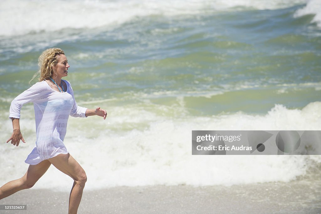 Side profile of a beautiful woman running on the beach