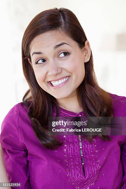 young woman looking away while biting lips - cheesy grin stock pictures, royalty-free photos & images