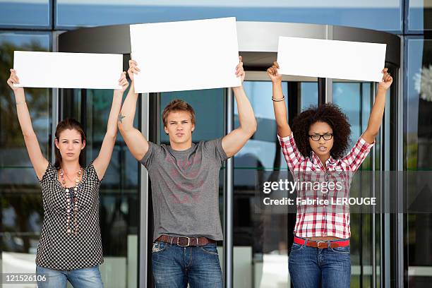 three friends protesting with blank placards - protester sign stock pictures, royalty-free photos & images