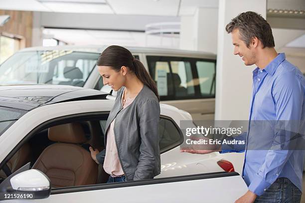 young woman checking car from inside while man holding the door - man opening door woman bildbanksfoton och bilder