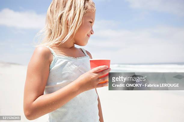 girl holding a disposable glass on the beach - african africa child drinking water cup stock pictures, royalty-free photos & images