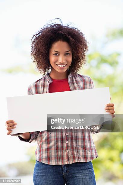 portrait of a woman holding a blank placard - white placard stock pictures, royalty-free photos & images