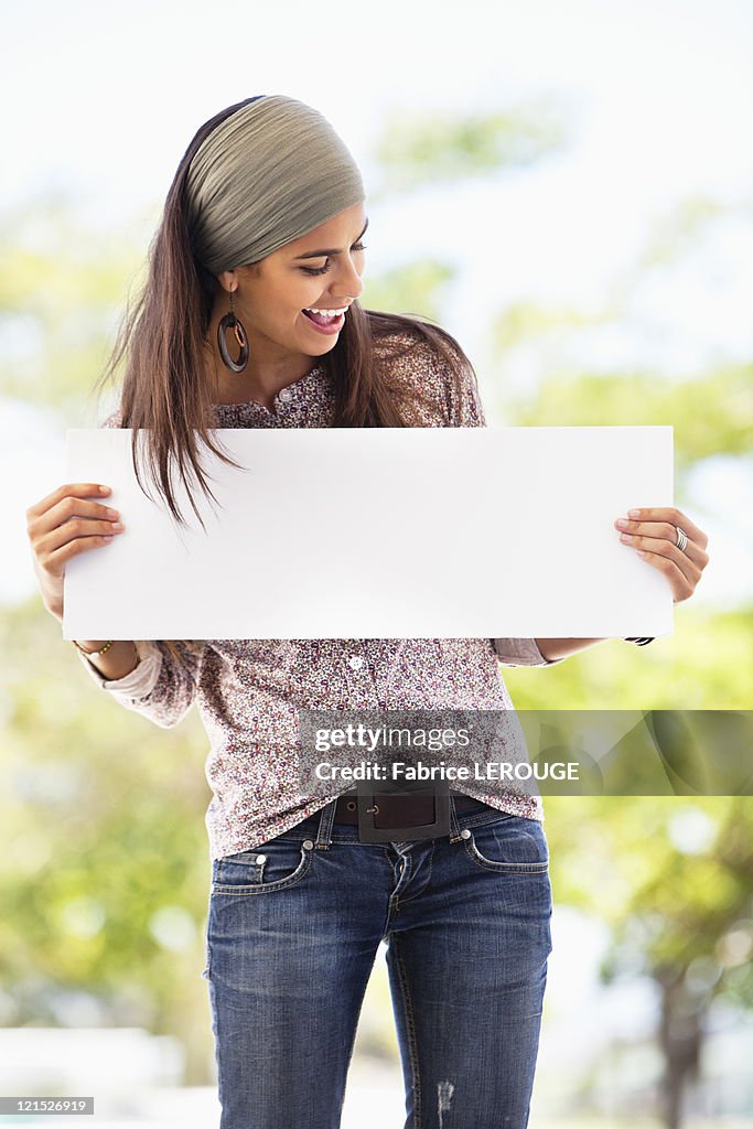 Smiling woman looking at a blank placard