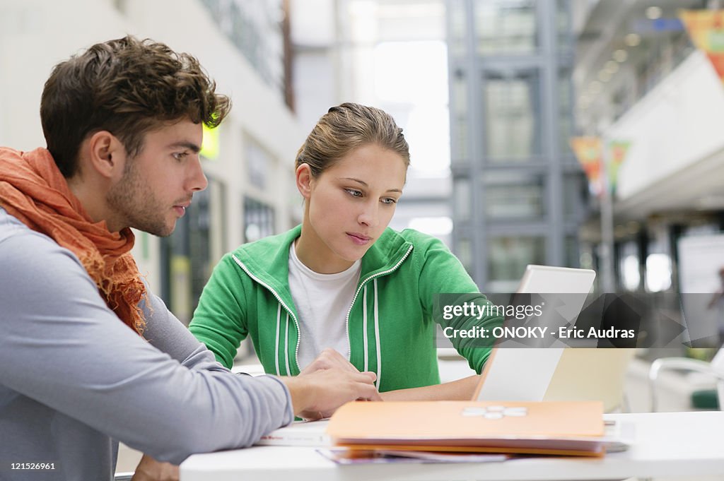 University students using laptop in lobby