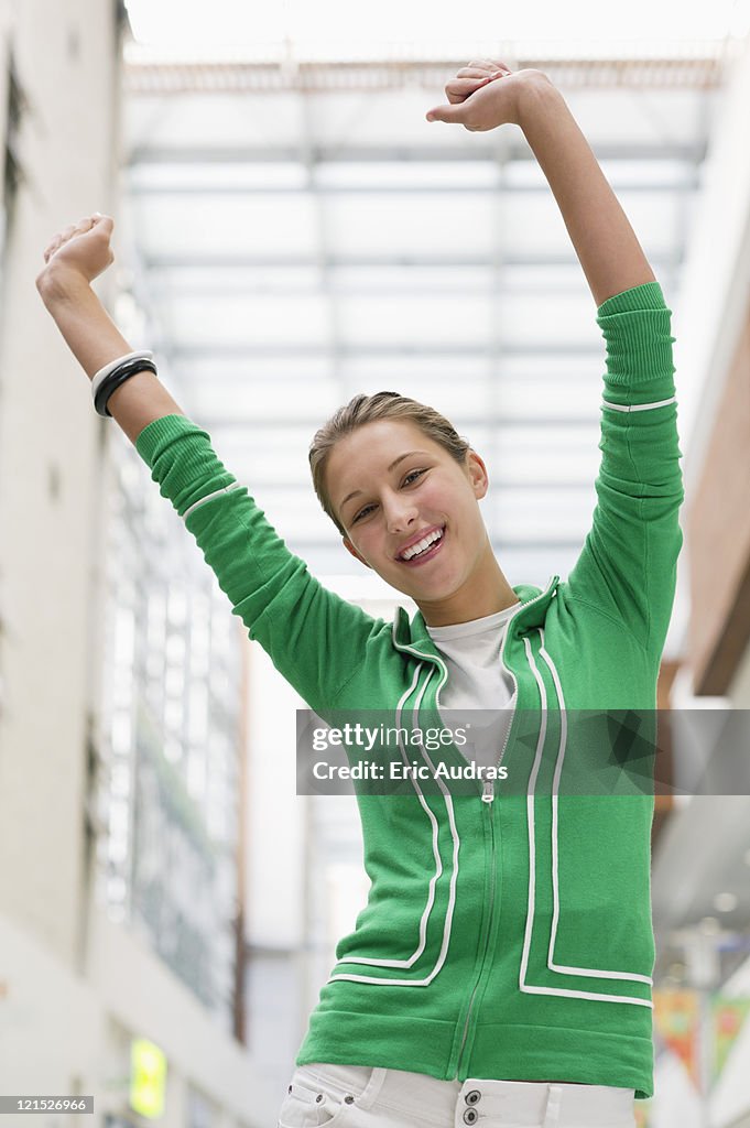 Portrait of an excited woman with arms raised