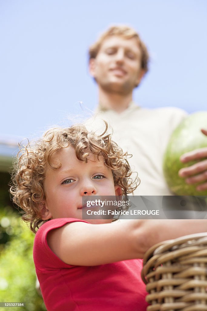 Low angle view of father and son holding fruits