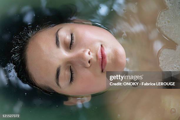 beautiful young woman relaxing in a bathtub with her eyes closed - beautiful woman bath photos et images de collection