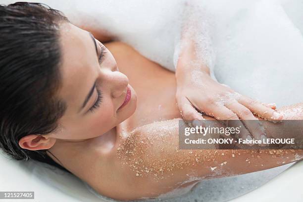 beautiful young woman taking bubble bath - bath salt stock pictures, royalty-free photos & images